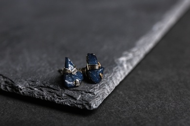Photo of Stylish studs on black background, space for text. Luxury jewelry