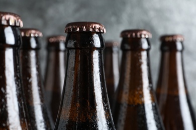 Bottles of beer on grey background, closeup