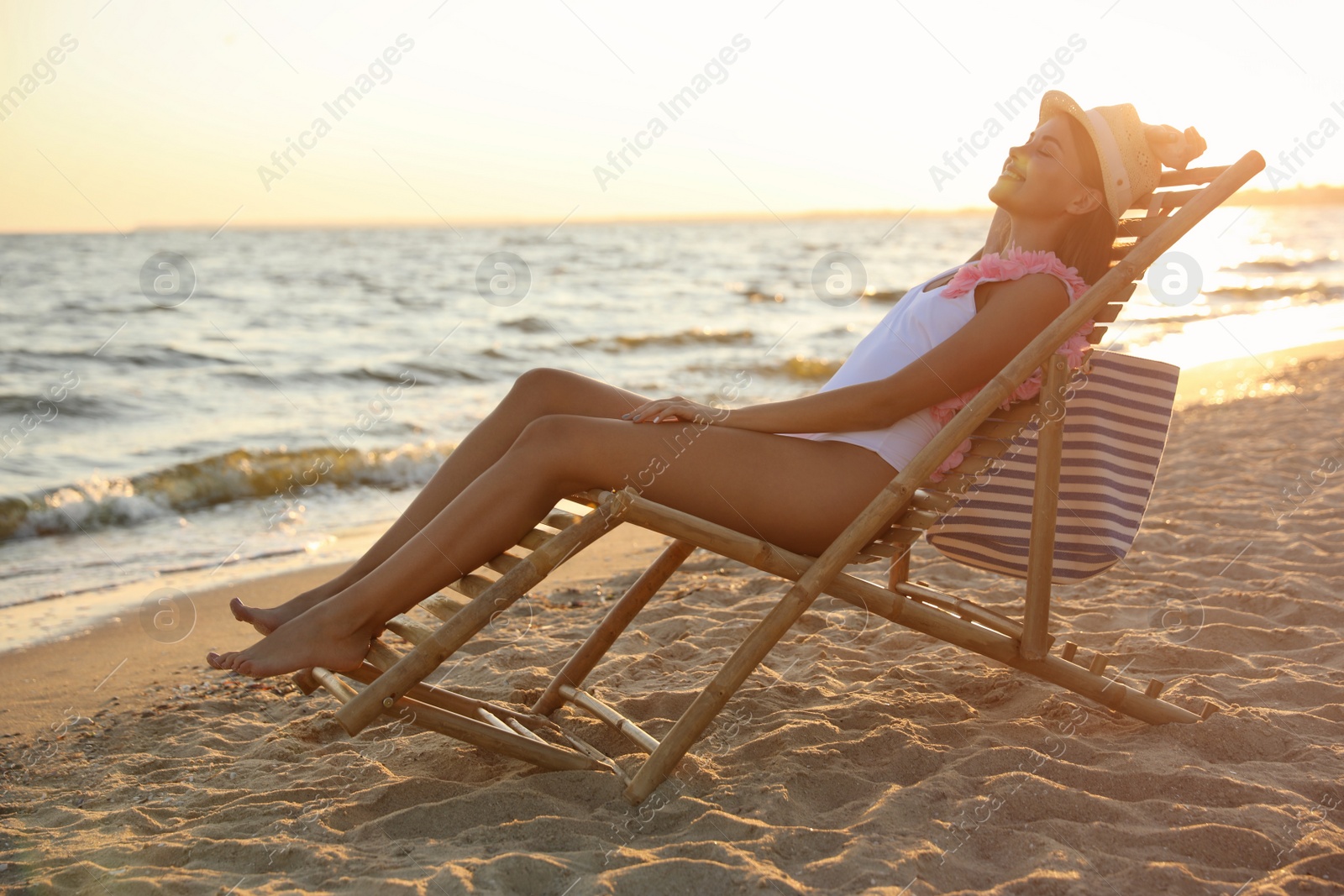 Photo of Young woman relaxing in deck chair on beach