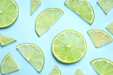 Photo of Juicy fresh lime slices on light blue background, flat lay