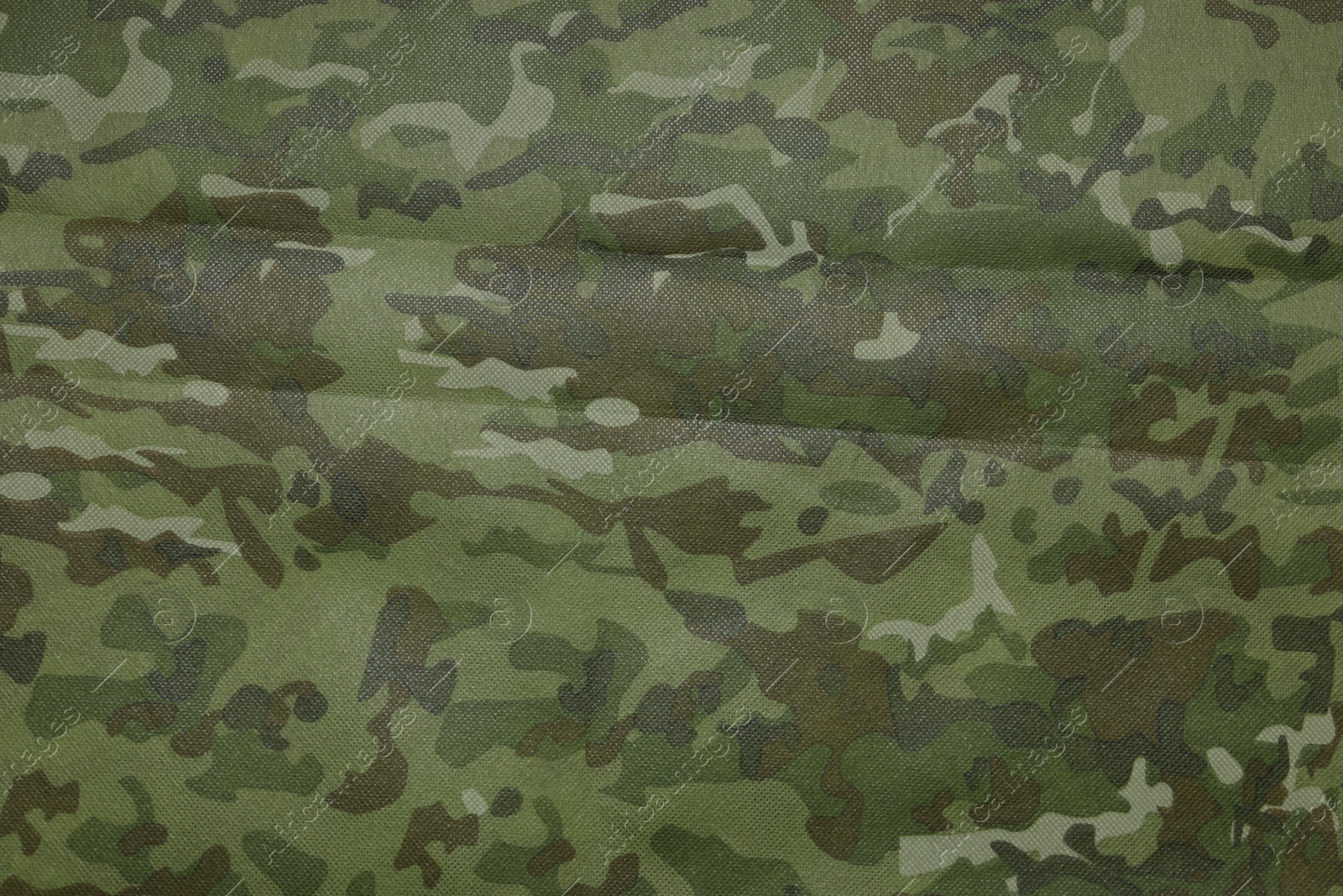 Photo of Texture of camouflage fabric as background, top view