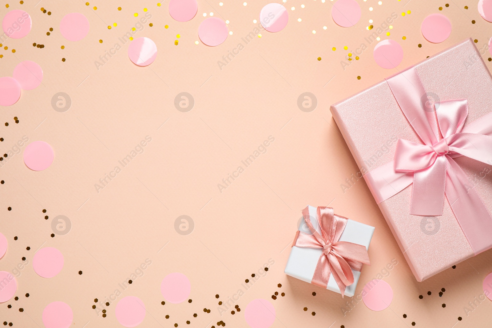 Photo of Frame of shiny confetti and beautiful gift boxes on color background, flat lay. Space for text
