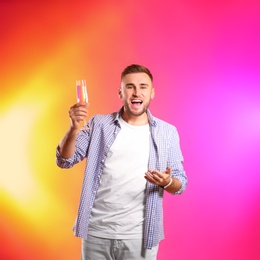 Portrait of happy man with champagne in glass on color background