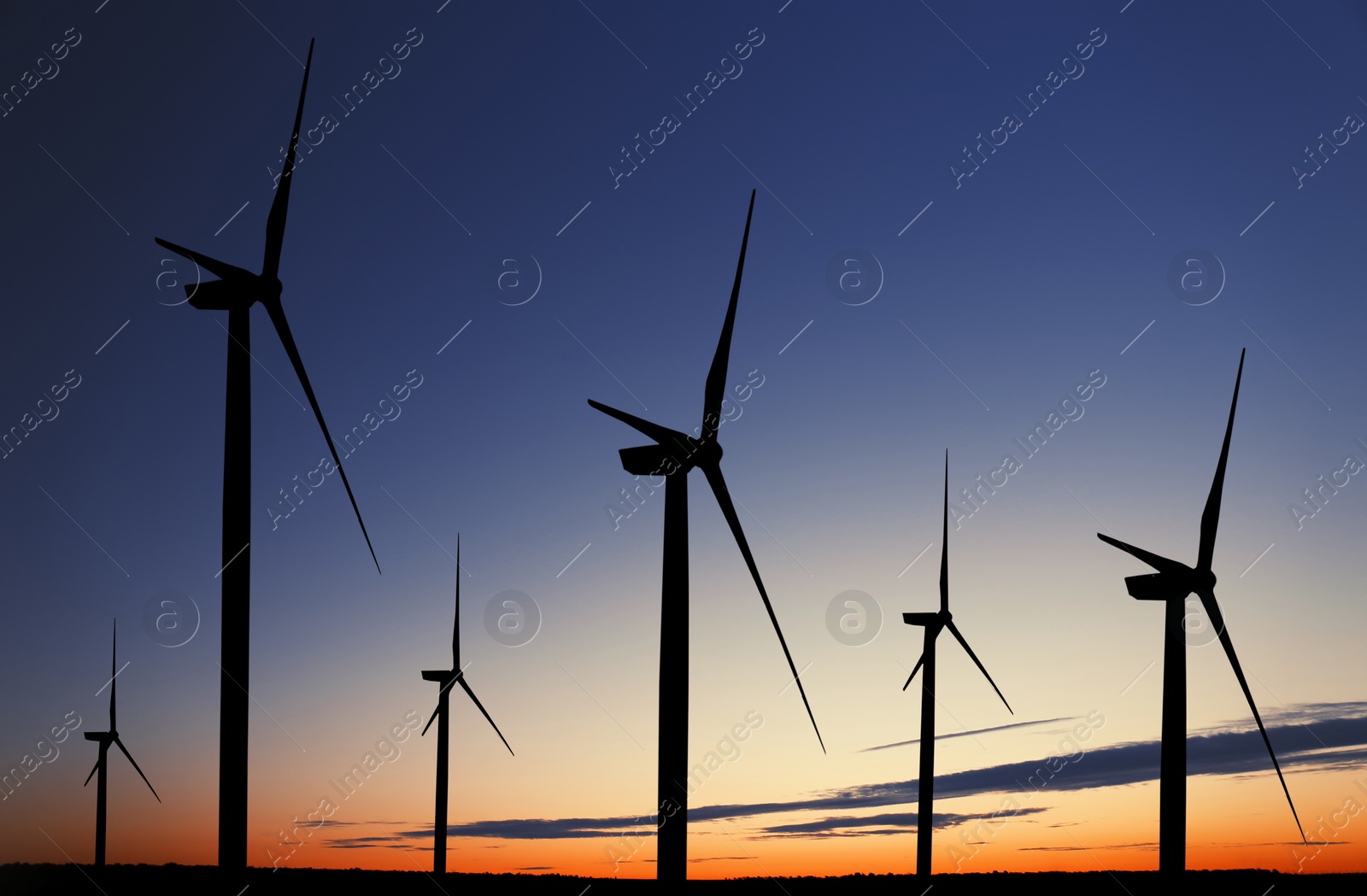 Image of Silhouettes of wind turbines at sunset. Alternative energy source