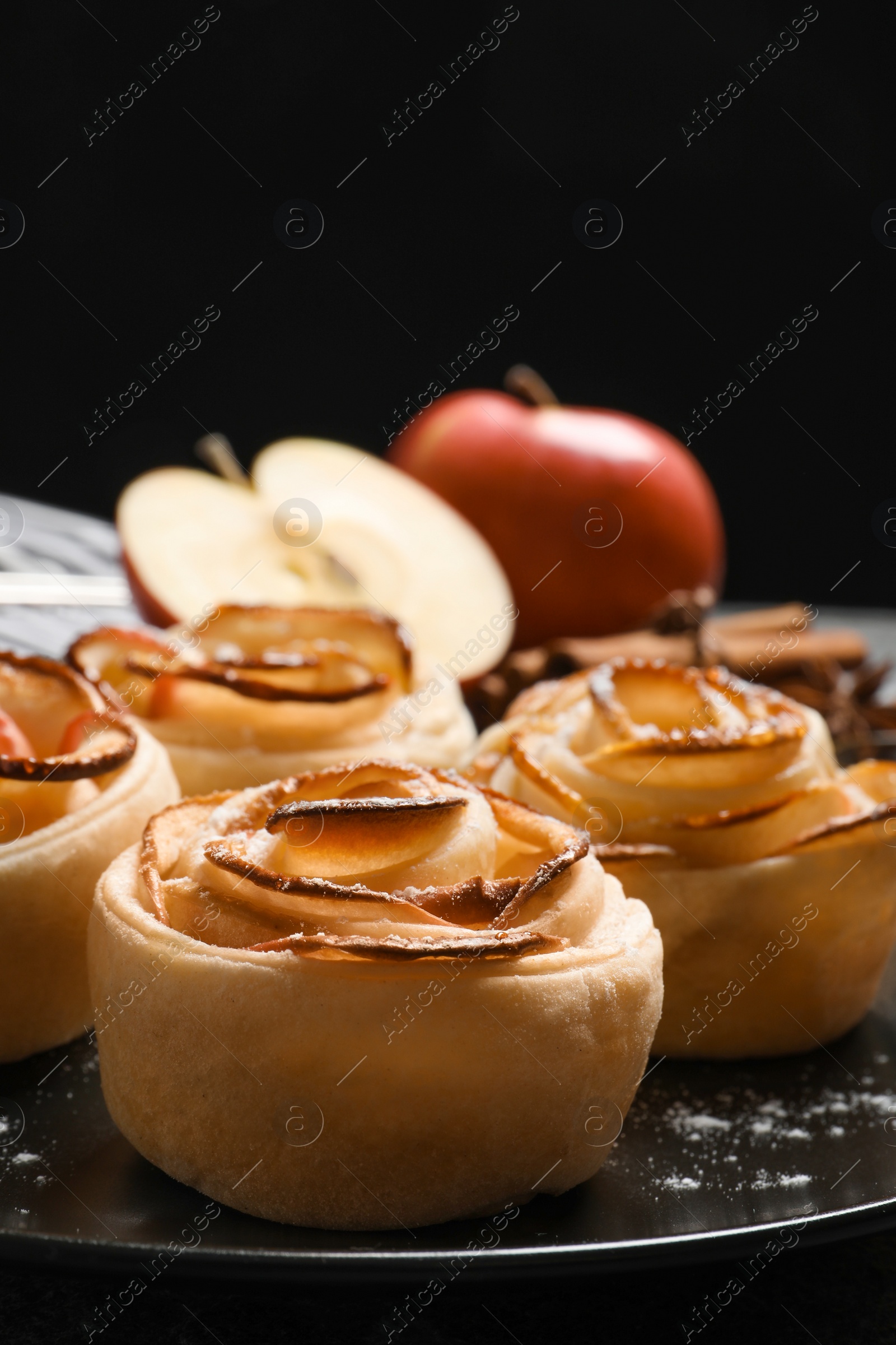 Photo of Freshly baked apple roses on black background. Beautiful dessert