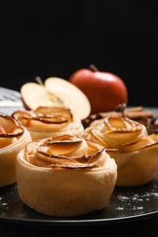 Freshly baked apple roses on black background. Beautiful dessert