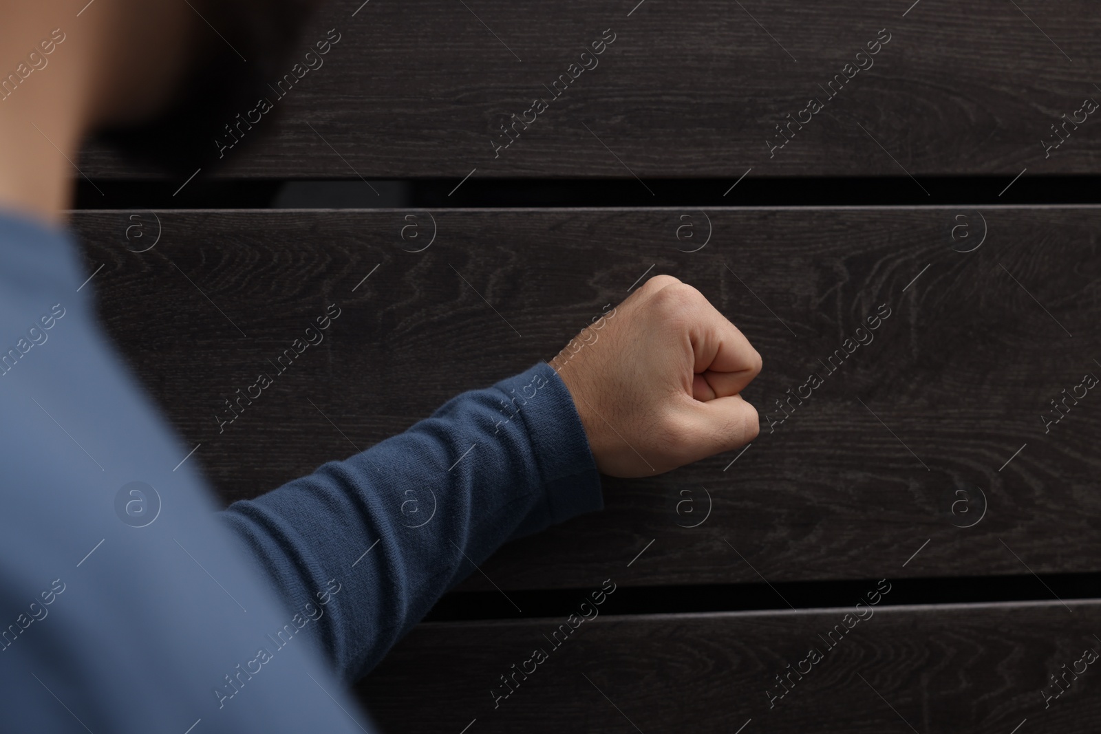 Photo of Collection agent knocking on wooden door, closeup