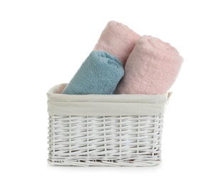 Photo of Rolled soft towels in basket on white background