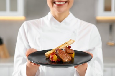 Closeup of professional chef presenting delicious dish in kitchen, focus on food