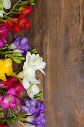 Beautiful freesia flowers on wooden background