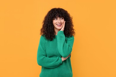 Photo of Happy young woman in stylish green sweater on yellow background
