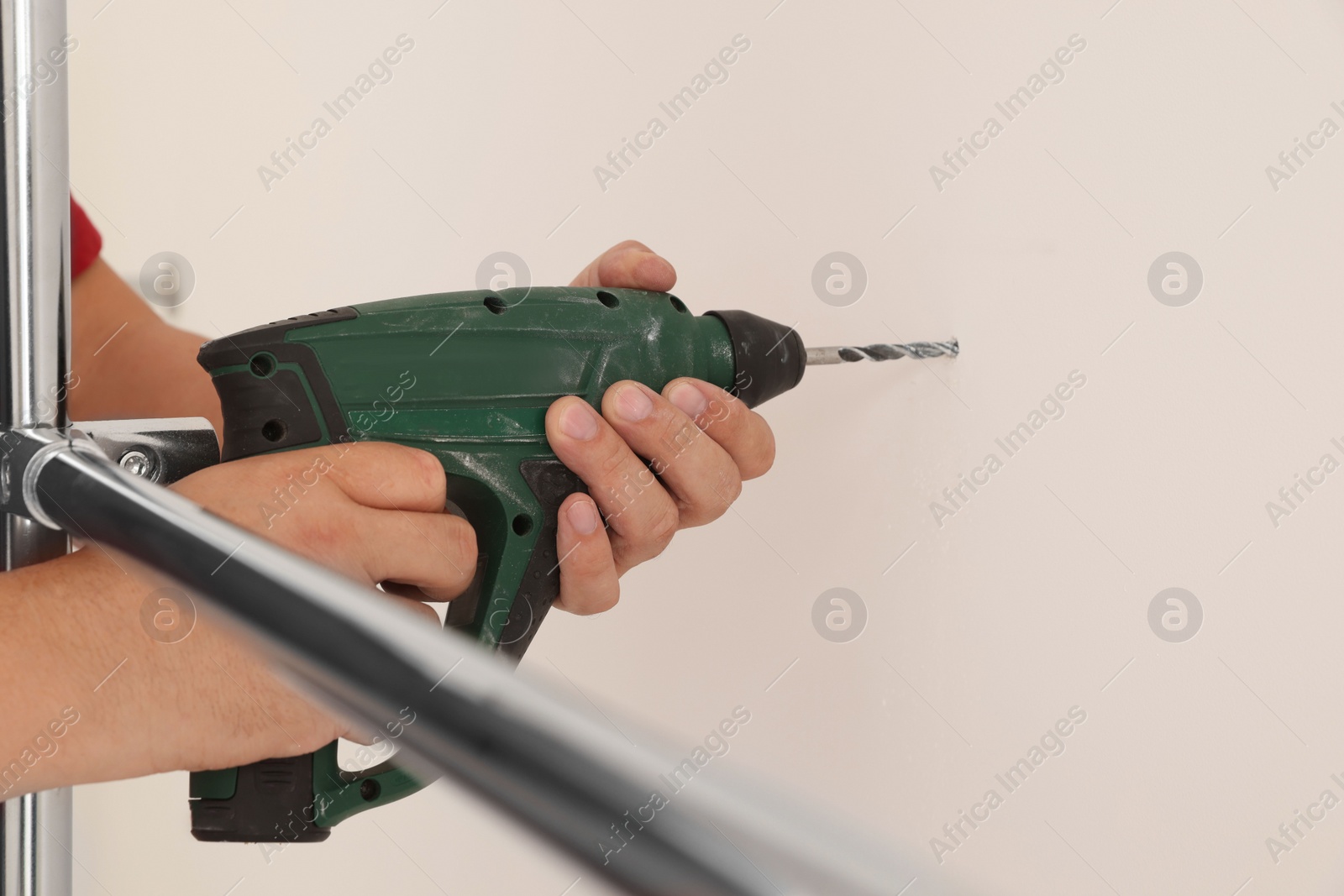 Photo of Worker installing new metal pipes with electric drill, closeup