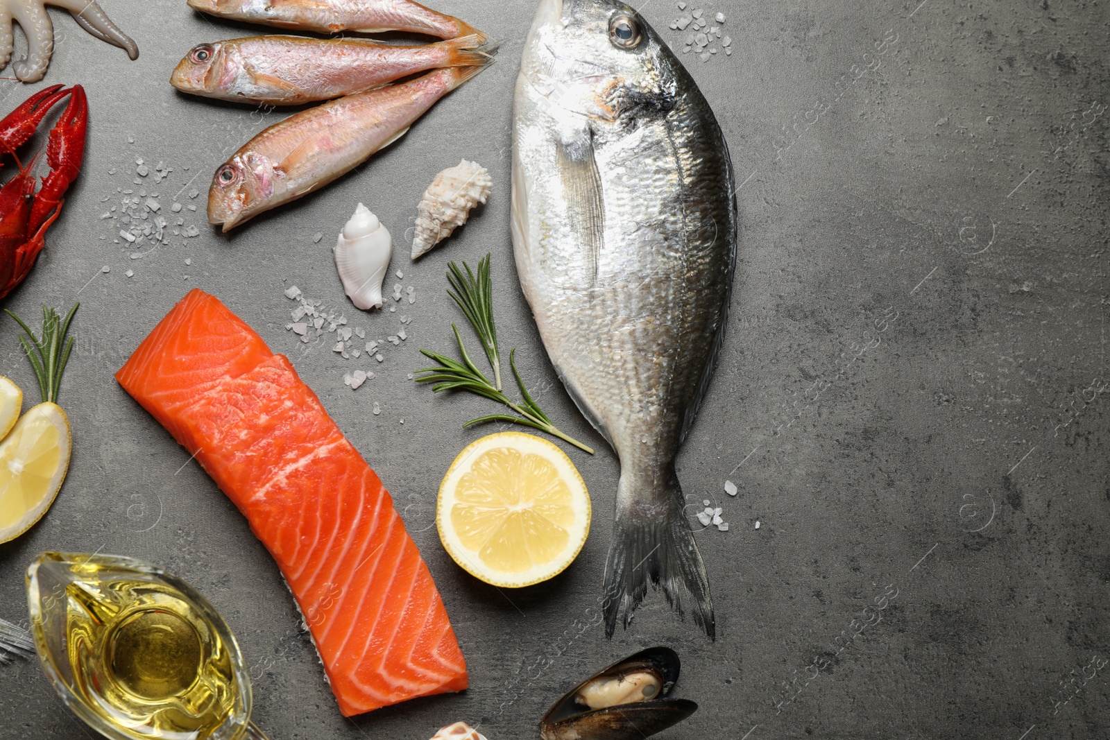 Photo of Fresh fish and seafood on grey table, flat lay