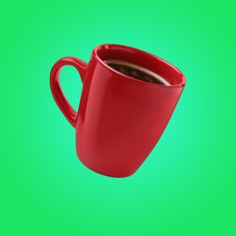 Image of Red cup of coffee levitating on green background