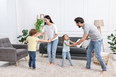 Happy family dancing and having fun in living room