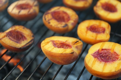 Photo of Modern grill with tasty cut peaches, closeup