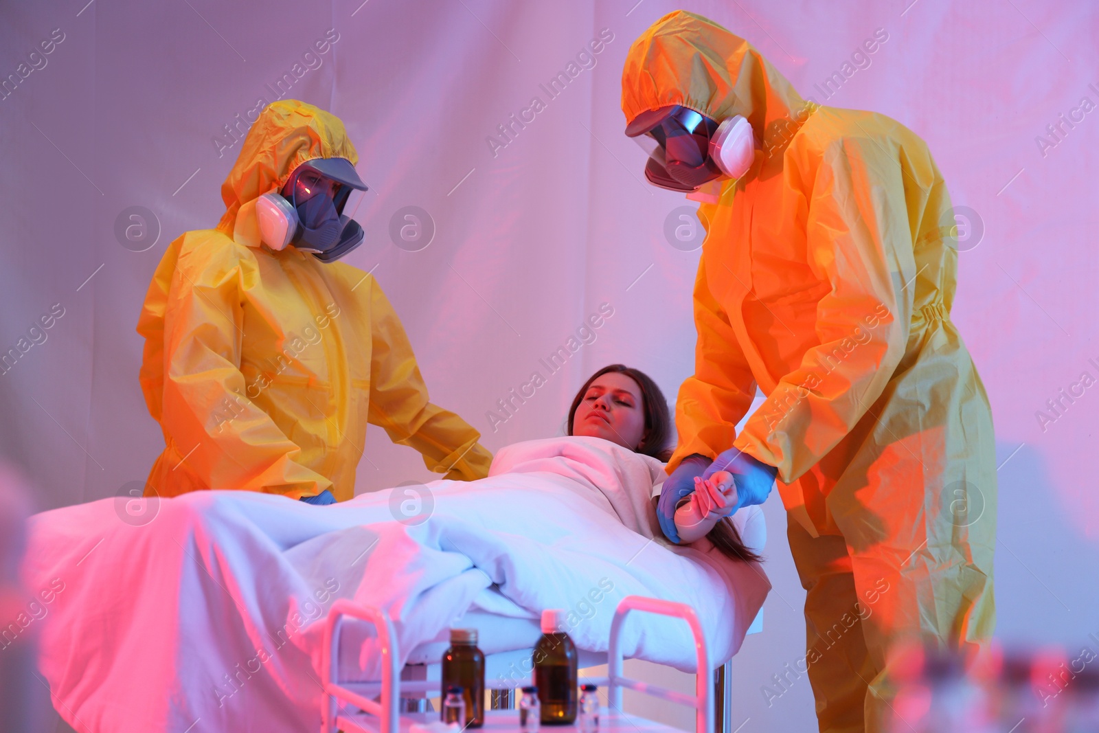 Photo of Professional paramedics examining patient with virus in quarantine ward