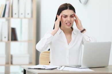 Image of Tired woman with red eyes at workplace in office