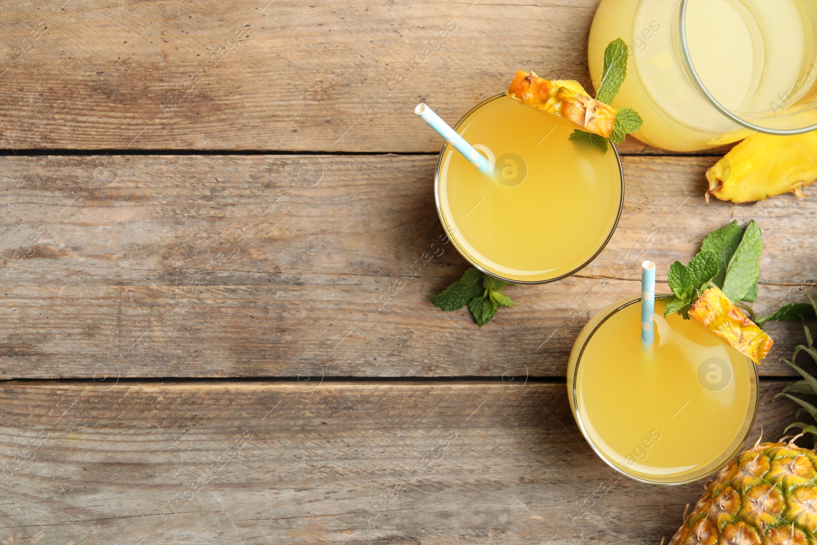 Photo of Delicious fresh pineapple juice with mint on wooden table, flat lay. Space for text