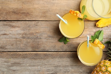 Photo of Delicious fresh pineapple juice with mint on wooden table, flat lay. Space for text