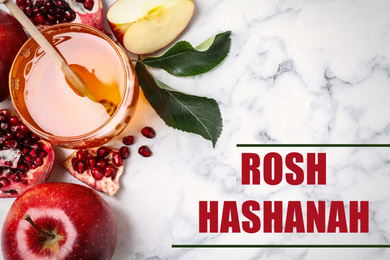 Honey, apples and pomegranate on white marble table, flat lay. Rosh Hashanah holiday