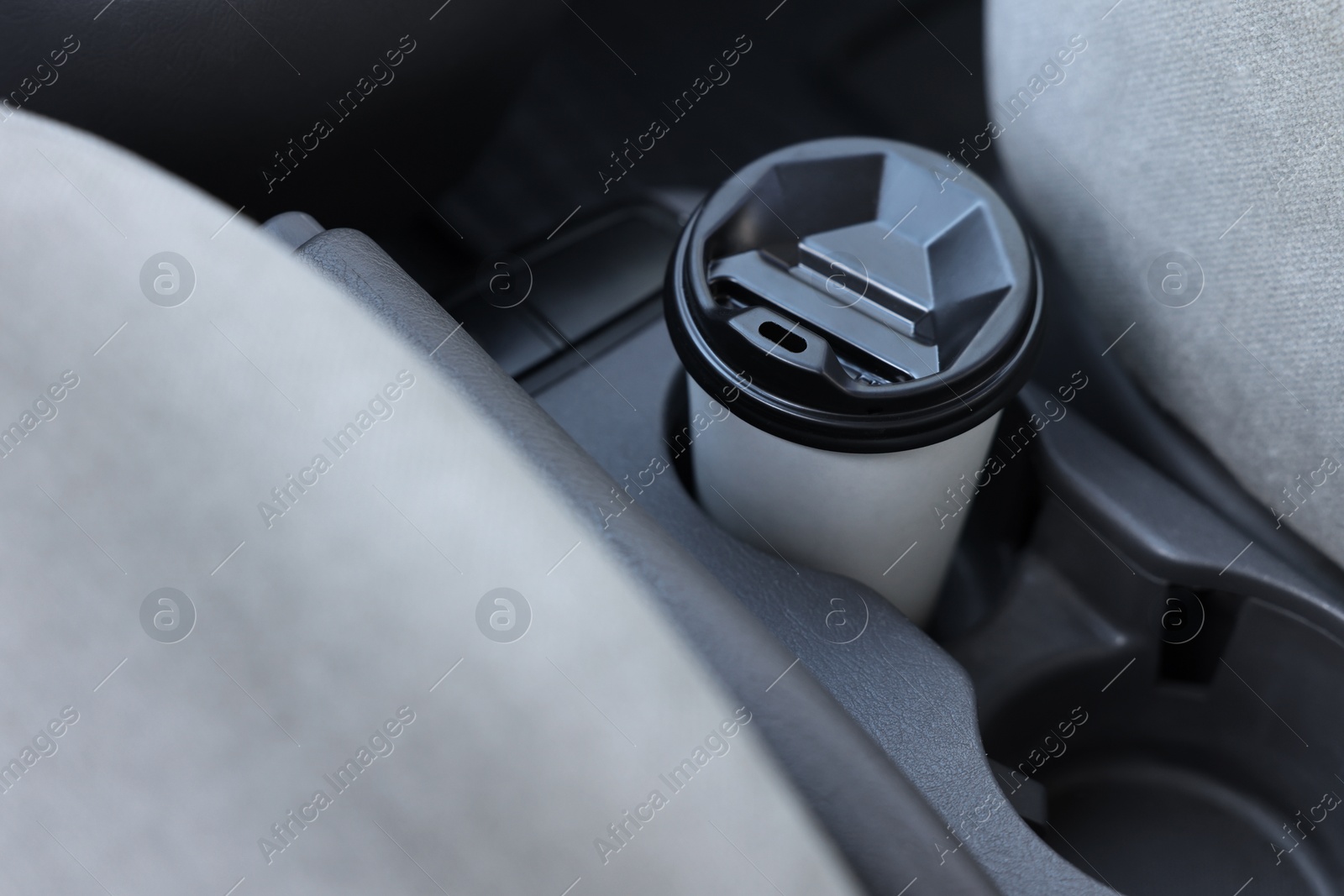 Photo of Coffee to go. Paper cup with tasty drink in holder inside of car