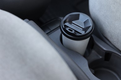 Coffee to go. Paper cup with tasty drink in holder inside of car