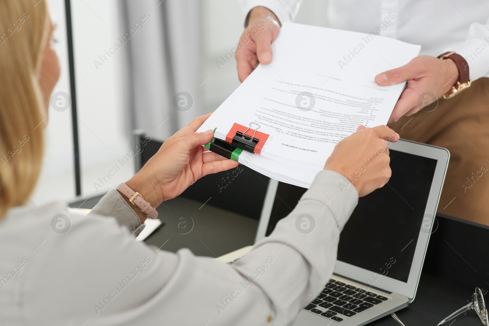 Photo of Woman giving documents to colleague in office, closeup