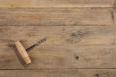 Photo of One corkscrew on wooden table, top view. Space for text