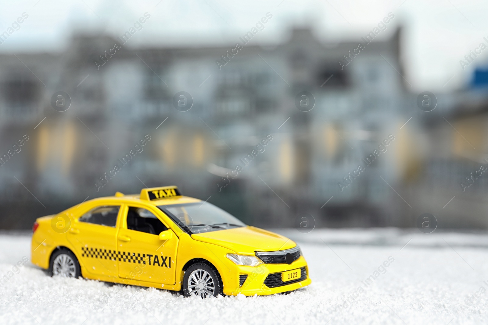 Photo of Yellow taxi car model on snow outdoors