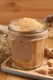 Jar with brown sugar on wooden table, closeup