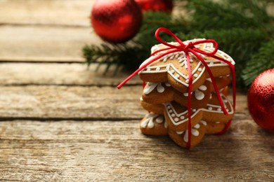 Tasty Christmas cookies with icing and festive decor on wooden table. Space for text