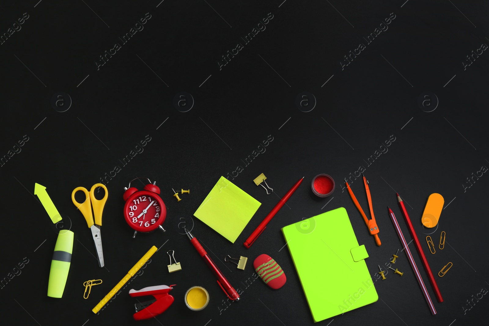 Photo of Different bright school stationery on black background, flat lay. Space for text