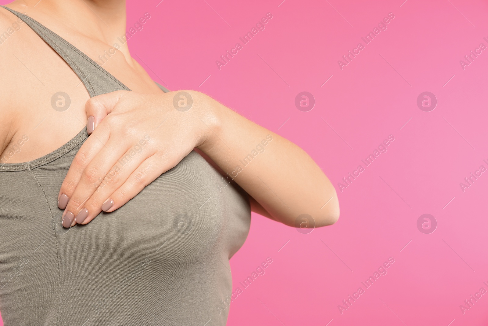 Photo of Woman checking her breast on color background, closeup. Space for text