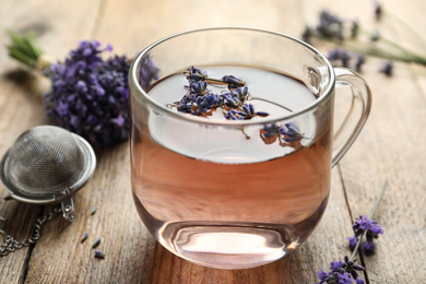 Fresh delicious tea with lavender in glass cup on wooden table