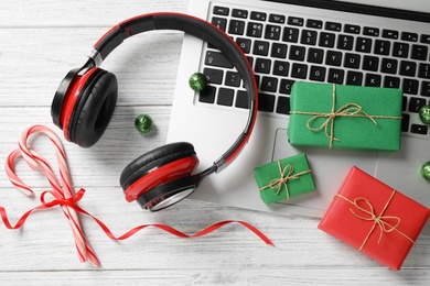 Flat lay composition with headphones on white wooden background. Christmas music