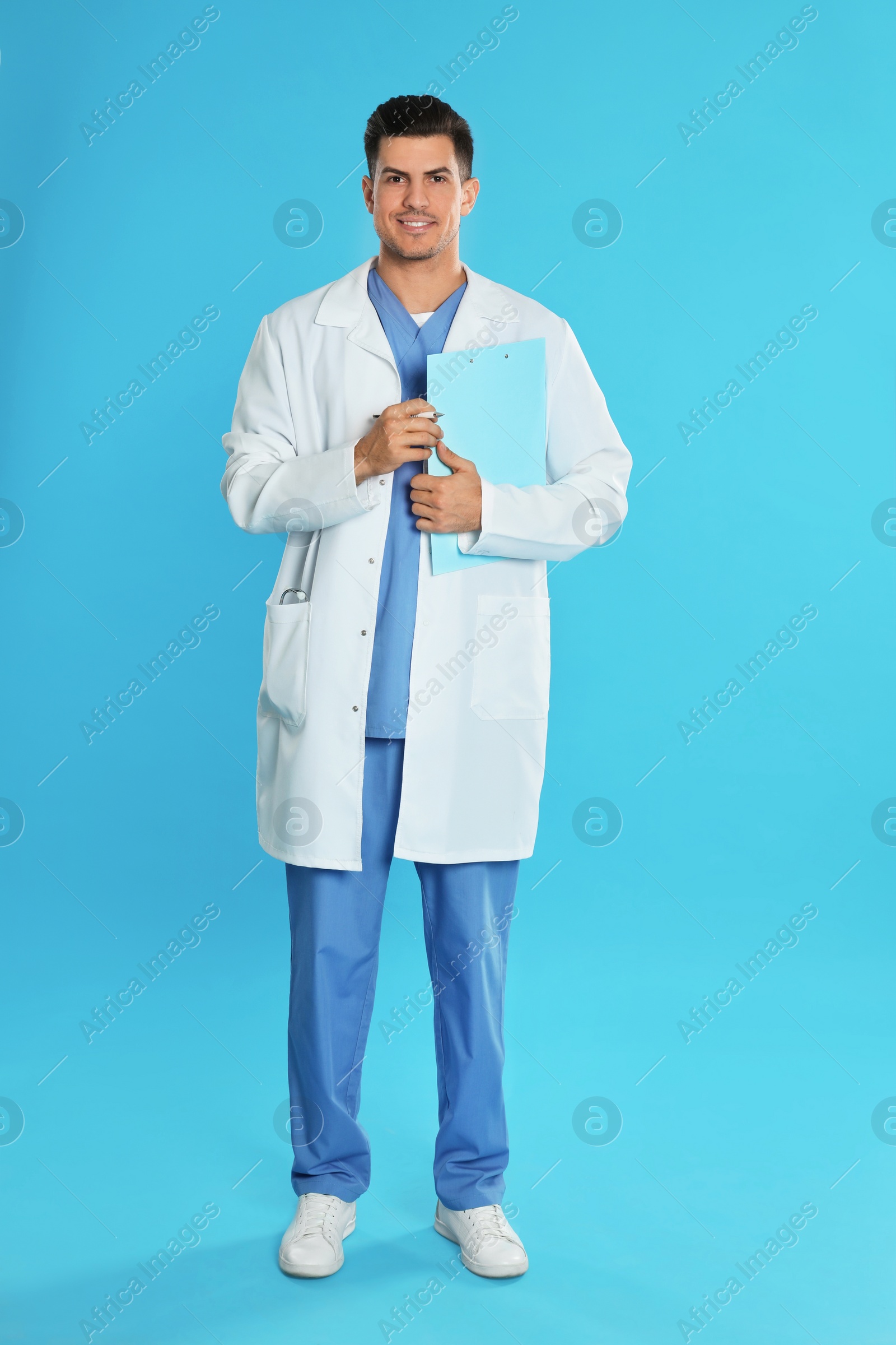 Photo of Doctor in uniform with clipboard on blue background