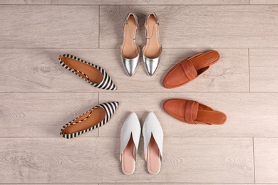 Photo of Different female shoes on wooden background, top view