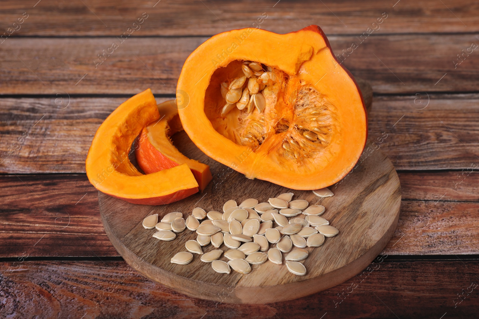 Photo of Fresh pumpkin and vegetable seeds on wooden table