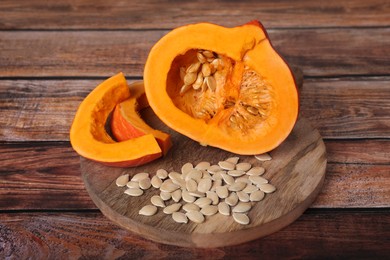 Photo of Fresh pumpkin and vegetable seeds on wooden table