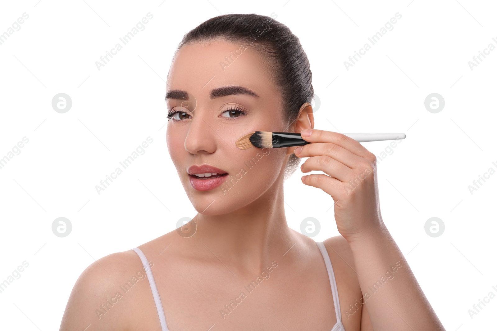 Photo of Woman applying foundation on face with brush against white background