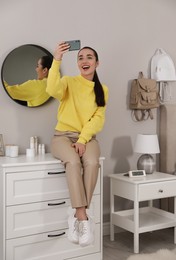 Photo of Young woman taking selfie at home in morning