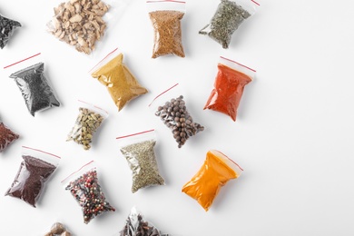 Photo of Plastic bags with different spices on white background, top view