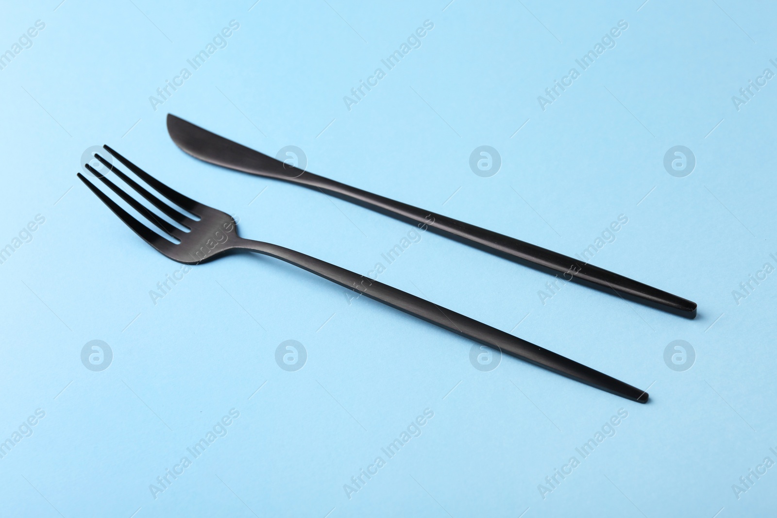 Photo of Stylish cutlery on light blue table, closeup