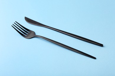 Stylish cutlery on light blue table, closeup