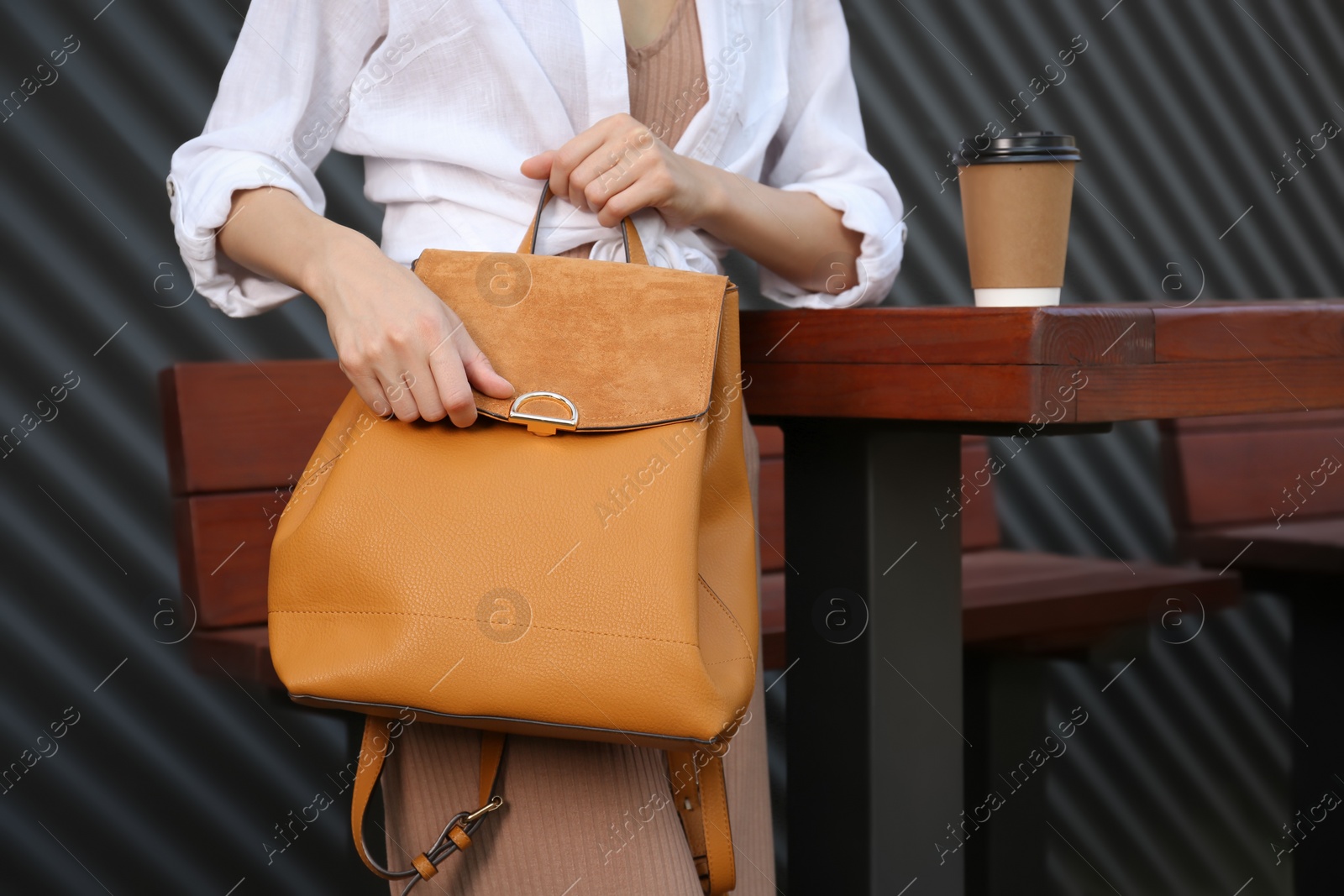 Photo of Young woman with stylish backpack in outdoor cafe, closeup