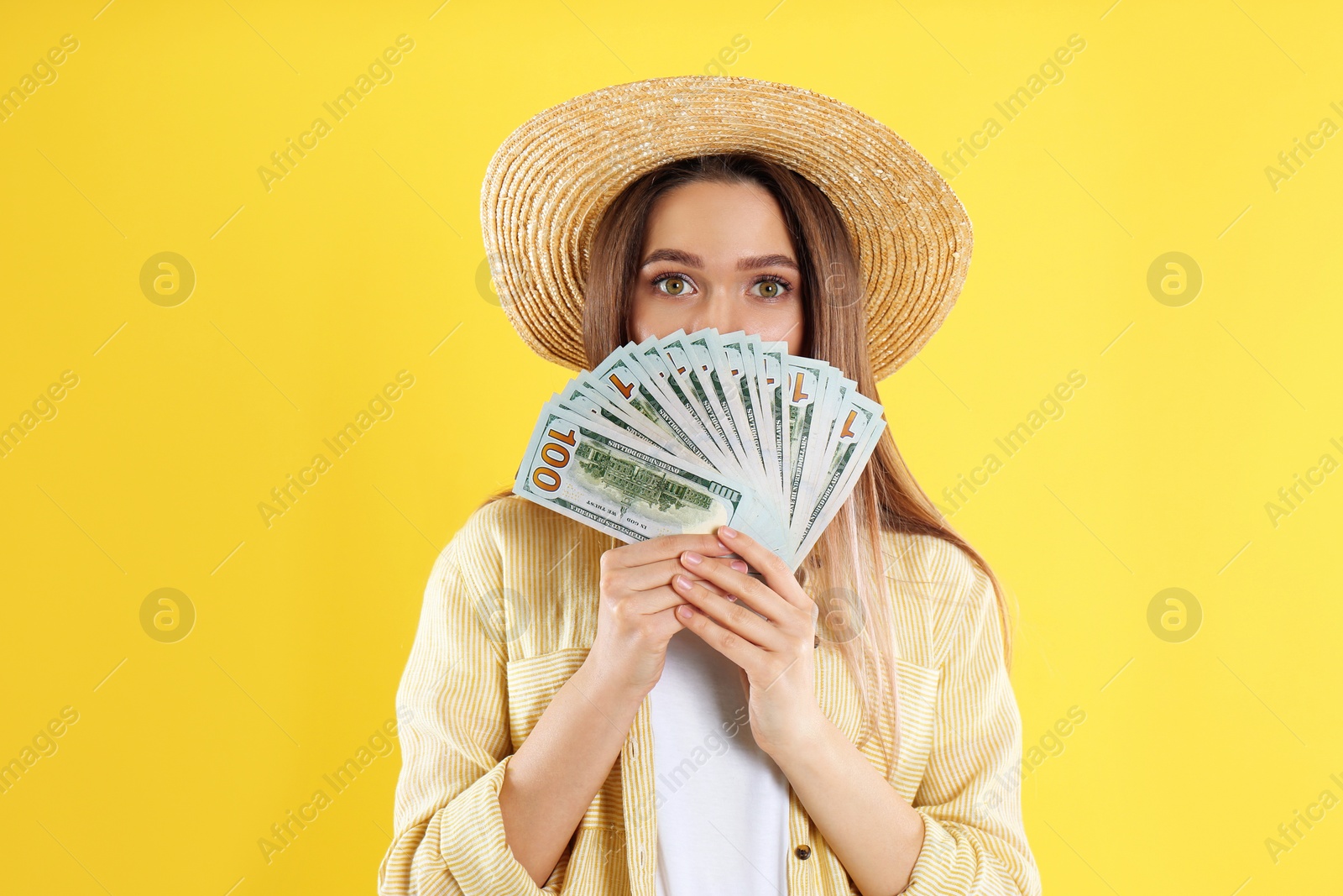 Photo of Young woman with money on yellow background