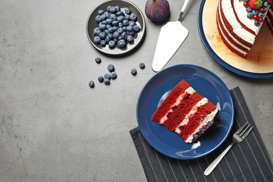 Photo of Flat lay composition with delicious red velvet cake and space for text on table