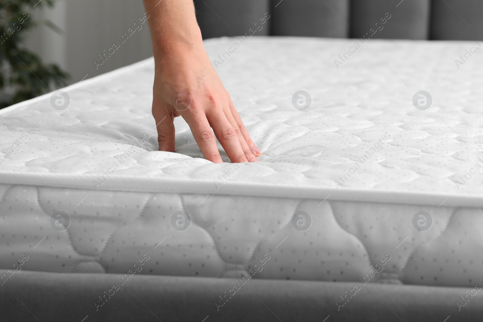 Photo of Man touching soft mattress indoors, closeup view