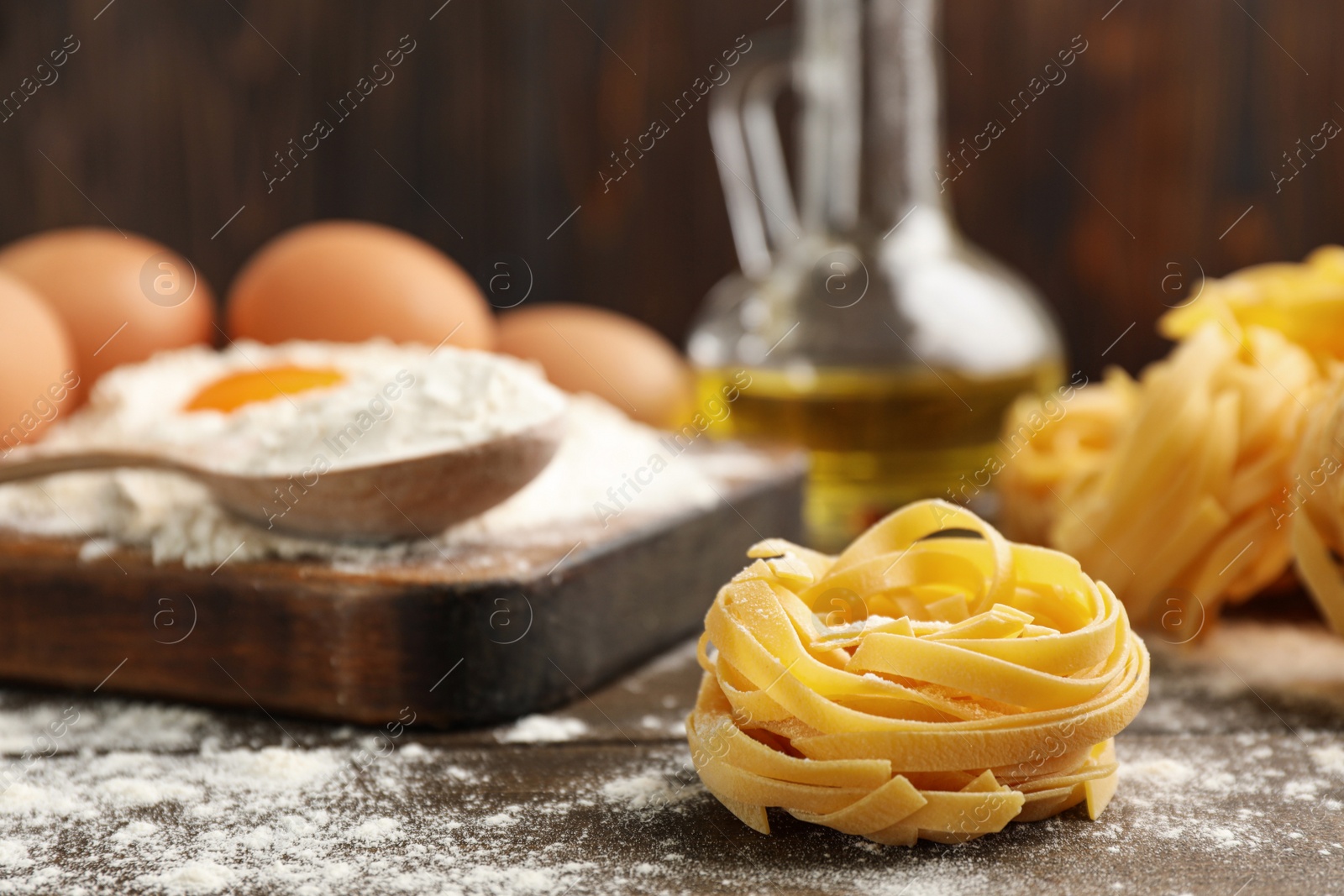 Photo of Raw noodles and ingredients on wooden table, space for text